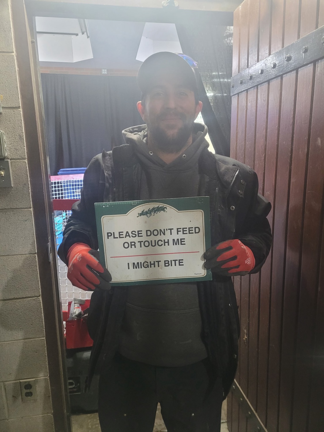Brandon holding a funny sign on the job
