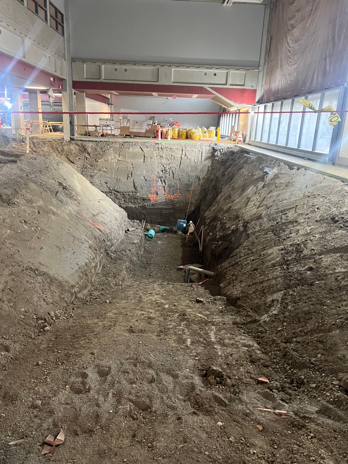 A large excavation inside a commercial building for a sewer line
