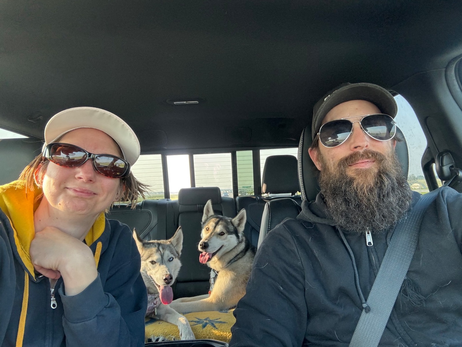 Brandon with his family and two huskies in the truck